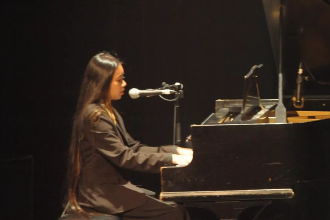 Skylar Keen singing at a grand piano on stage
